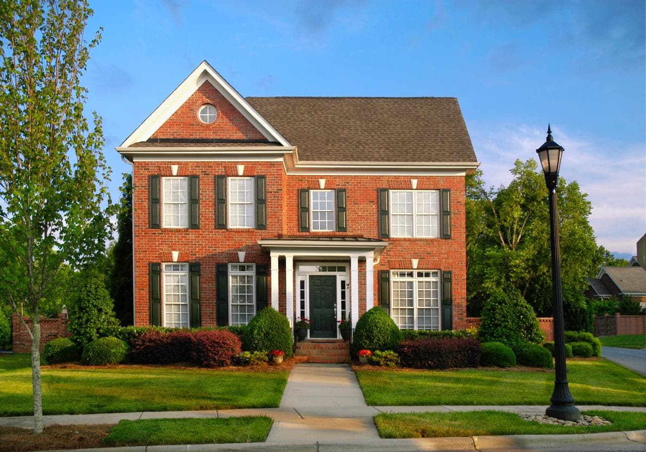 Large brick single-family home with a front lawn